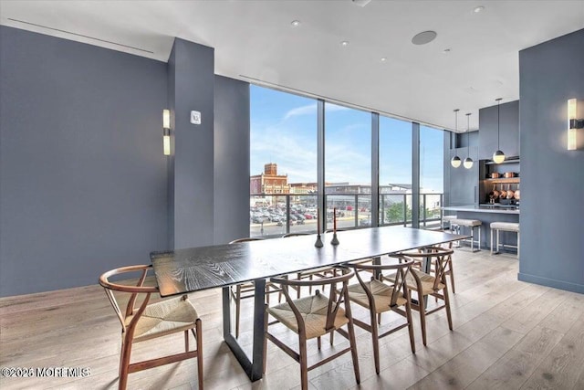 dining room with floor to ceiling windows and light hardwood / wood-style floors