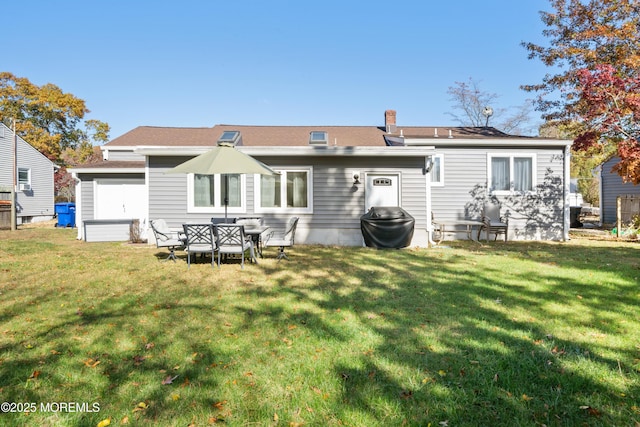 rear view of property featuring a lawn