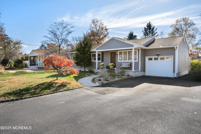 single story home with a front yard, covered porch, and a garage