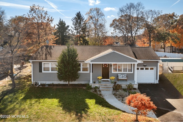 ranch-style house featuring a front yard, covered porch, and a garage