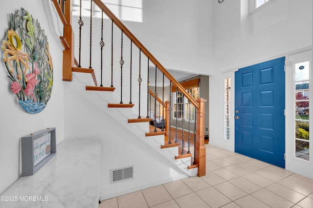 tiled foyer with a towering ceiling