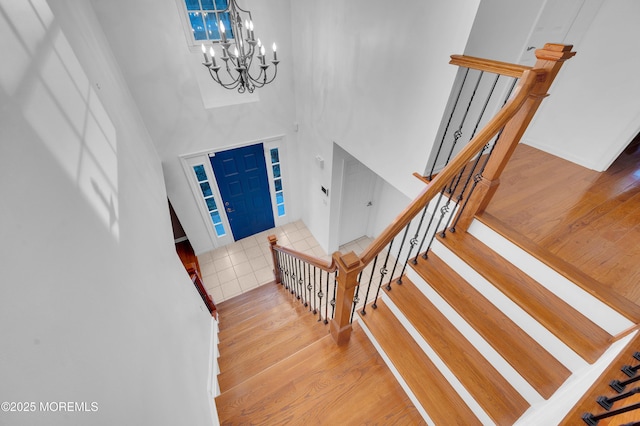 foyer entrance featuring a high ceiling, a chandelier, and wood-type flooring