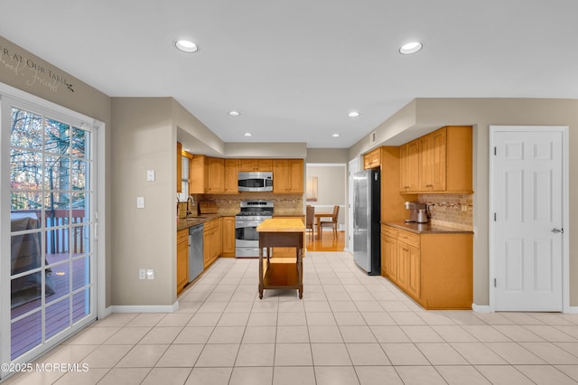 kitchen with stainless steel appliances, light tile patterned flooring, sink, and backsplash