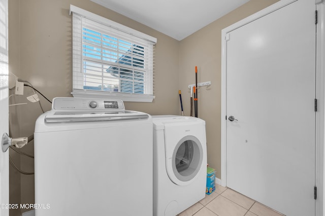 laundry area featuring washing machine and dryer and light tile patterned floors