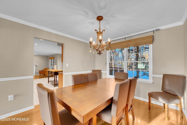 dining space with light hardwood / wood-style flooring, crown molding, and a chandelier