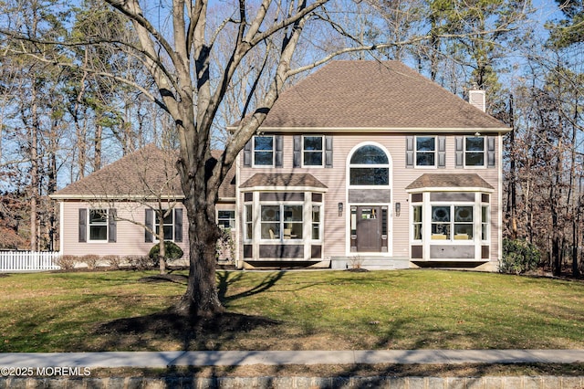 colonial-style house with a front yard and a sunroom