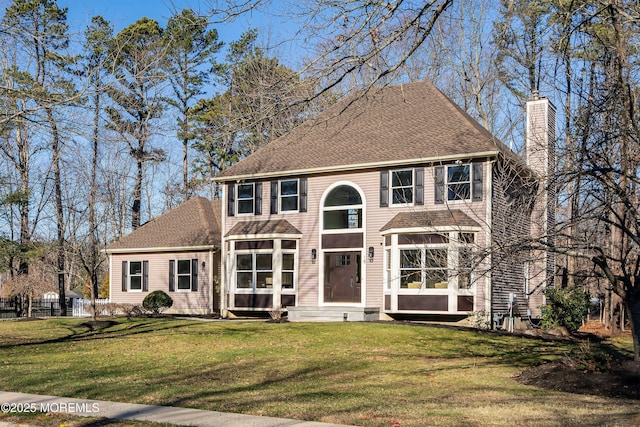 colonial-style house featuring a front lawn