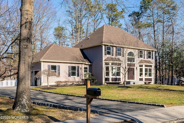 view of front of house with a front yard and a garage