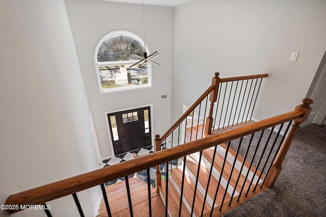 carpeted entrance foyer featuring a towering ceiling