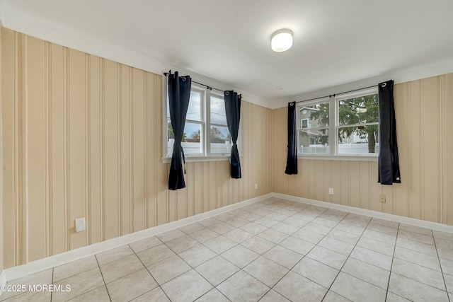 empty room with tile patterned floors and ornamental molding