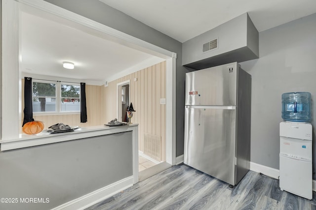 kitchen with wood-type flooring and stainless steel fridge