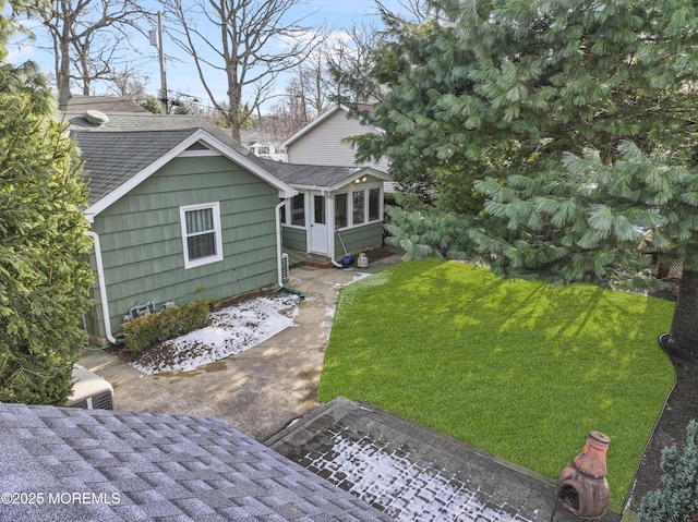 rear view of house with a yard and a sunroom