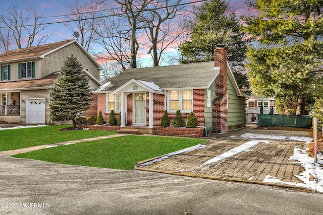 view of front of property featuring a lawn and a garage