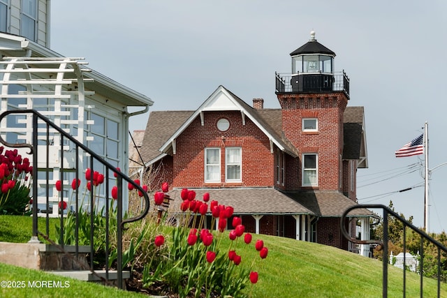 view of front facade featuring a front yard and a balcony