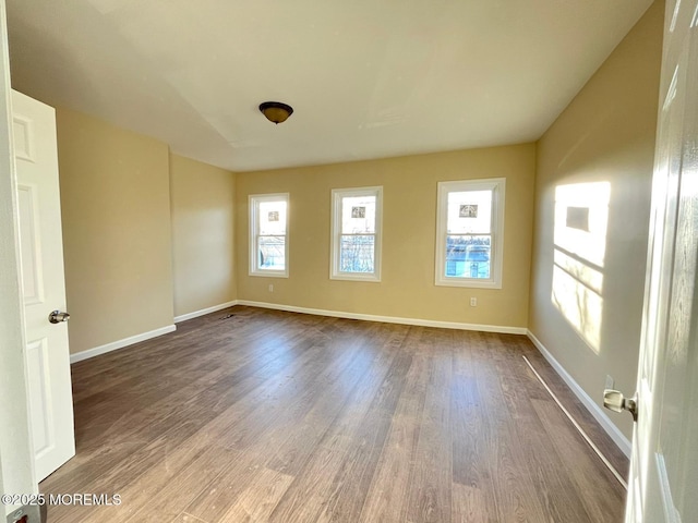 spare room with plenty of natural light and hardwood / wood-style floors