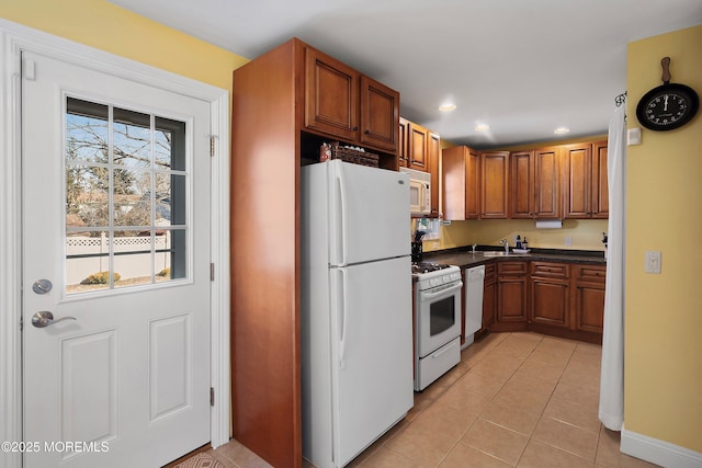 kitchen featuring white appliances, sink, and light tile patterned floors