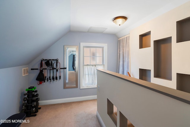 hall featuring vaulted ceiling and light carpet