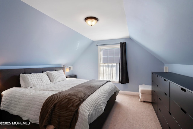 bedroom with lofted ceiling and light colored carpet