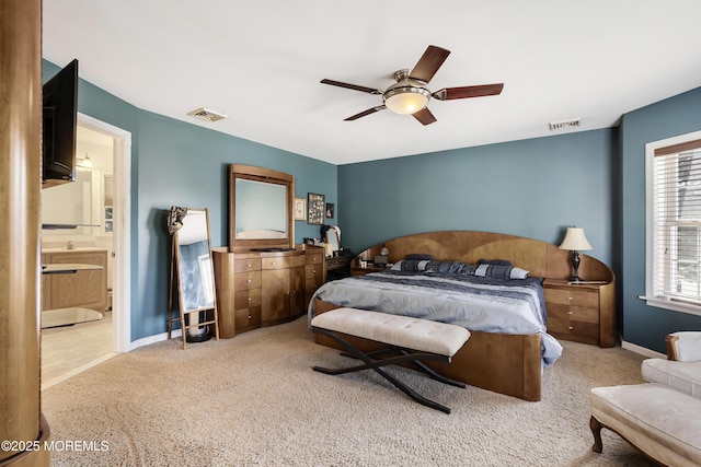 carpeted bedroom featuring ensuite bath and ceiling fan