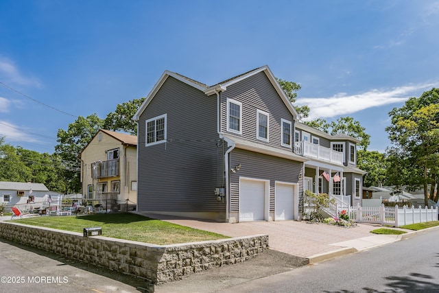 view of front of property with a garage, a balcony, and a front yard