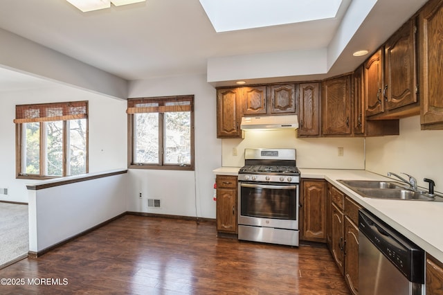 kitchen featuring sink, appliances with stainless steel finishes, dark hardwood / wood-style floors, and a skylight