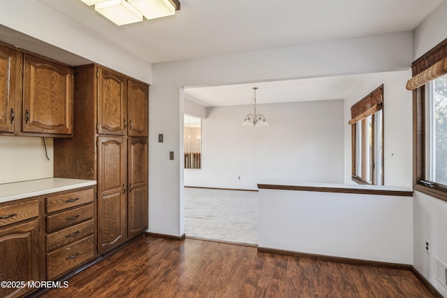 kitchen with decorative light fixtures, dark hardwood / wood-style flooring, and an inviting chandelier