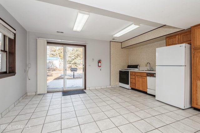 kitchen with light tile patterned floors, sink, and white appliances