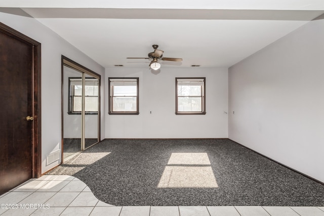 unfurnished bedroom featuring light carpet, a closet, and ceiling fan