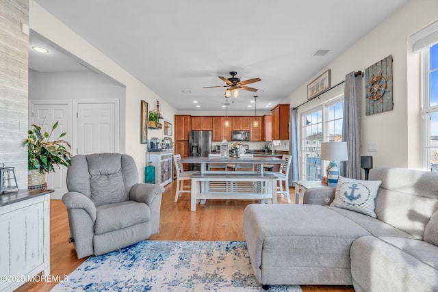 living room with ceiling fan and light hardwood / wood-style floors