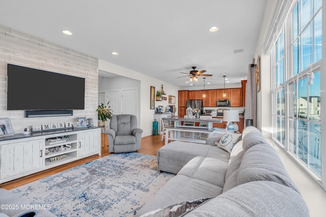 living room with light wood-type flooring and ceiling fan