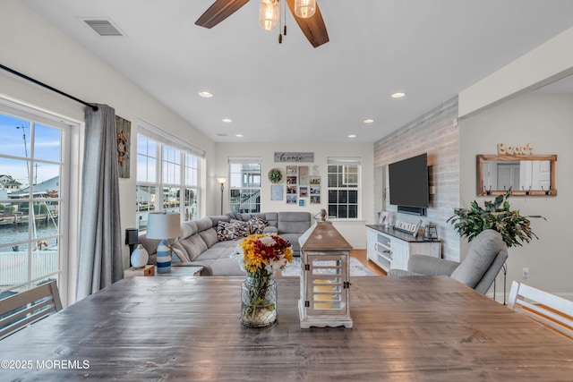 dining room with a water view and ceiling fan