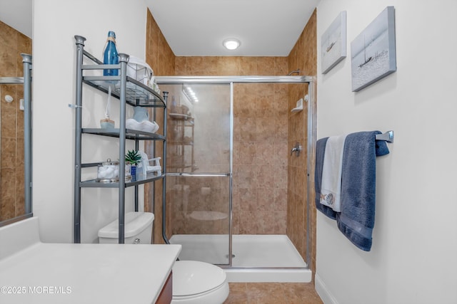 bathroom featuring tile patterned flooring, vanity, toilet, and an enclosed shower