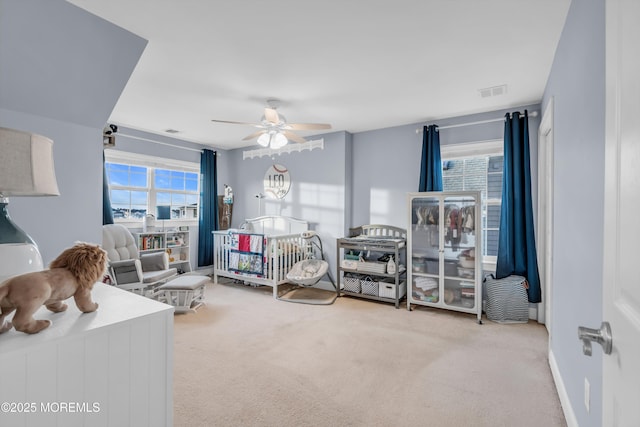 carpeted bedroom with multiple windows and ceiling fan