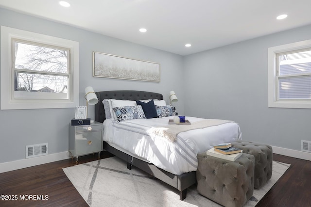 bedroom with dark hardwood / wood-style flooring and multiple windows