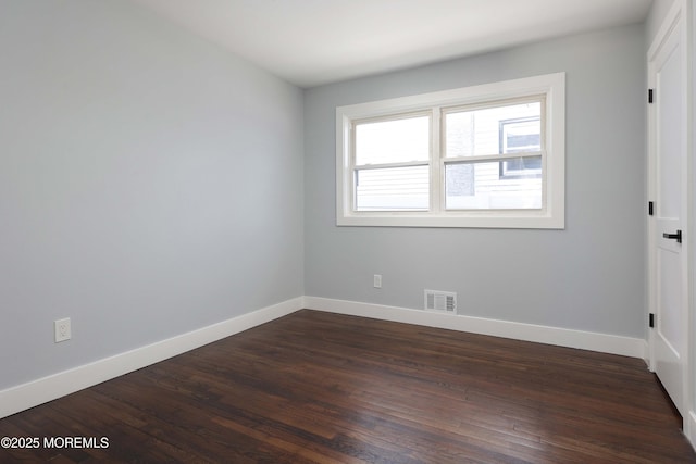 spare room with dark wood-type flooring