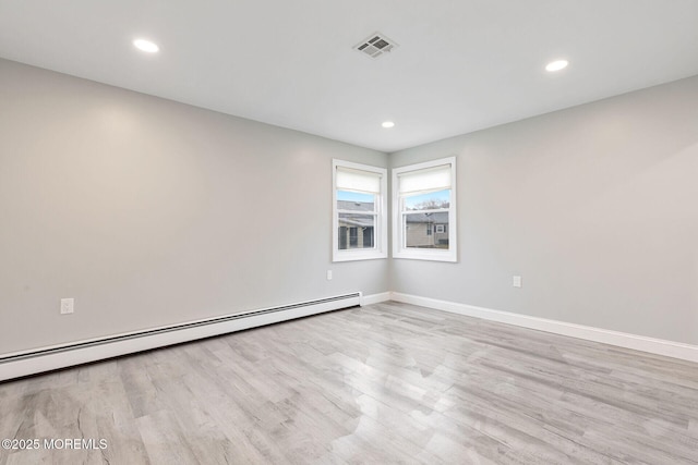 spare room featuring light hardwood / wood-style flooring and a baseboard heating unit