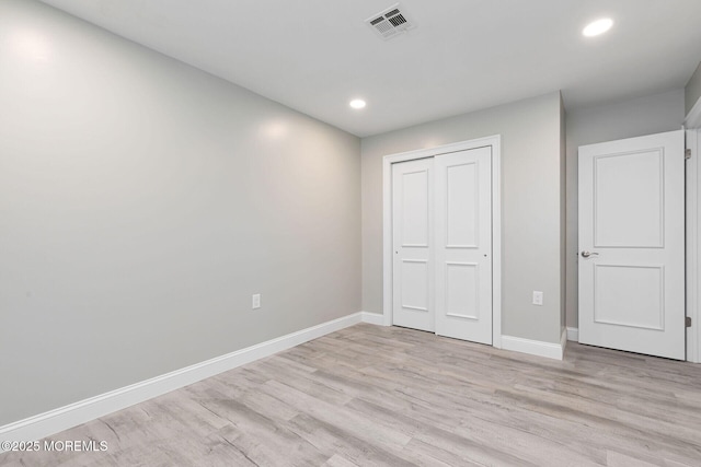 unfurnished bedroom featuring a closet and light hardwood / wood-style flooring