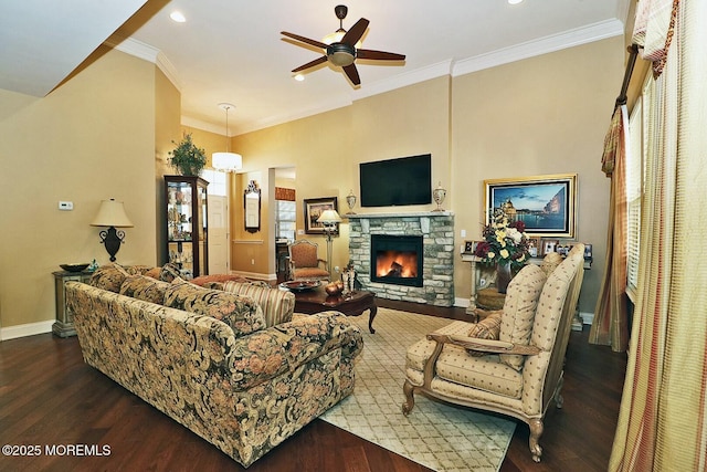 living room with hardwood / wood-style flooring, ceiling fan, crown molding, and a fireplace