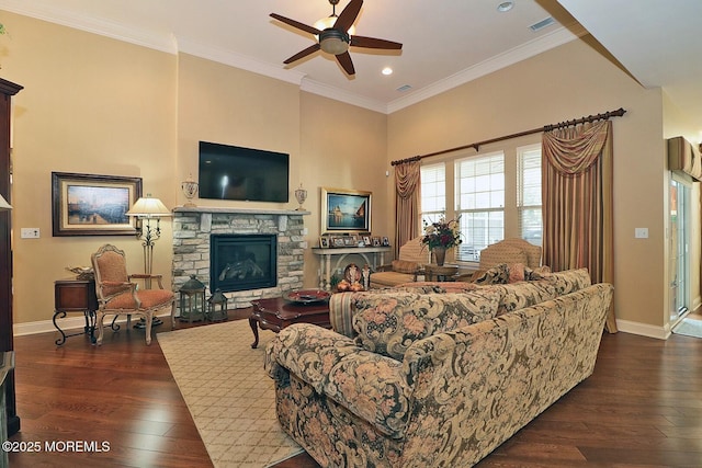 living room with dark hardwood / wood-style flooring, a fireplace, ceiling fan, and crown molding