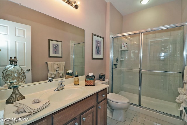 bathroom featuring toilet, a shower with door, vanity, and tile patterned floors