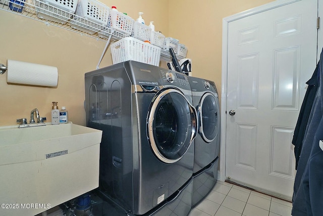 washroom featuring washer and dryer, sink, and light tile patterned floors