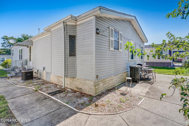 view of side of home featuring central AC unit and a patio area