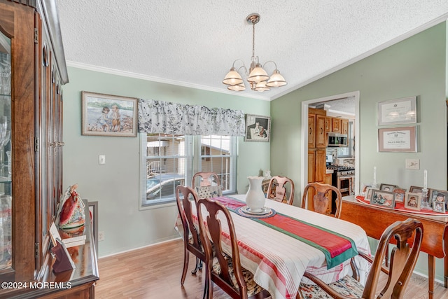 dining room featuring a textured ceiling, light hardwood / wood-style floors, vaulted ceiling, and an inviting chandelier