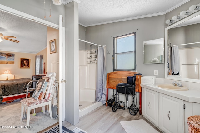 bathroom with ceiling fan, a shower, wood-type flooring, and a textured ceiling