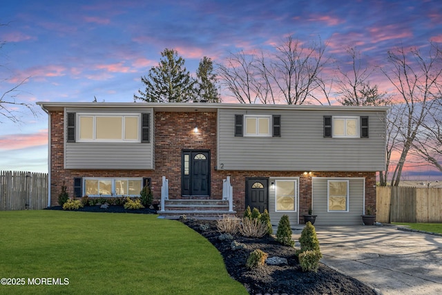 split foyer home featuring a yard