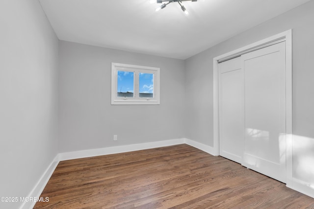 unfurnished bedroom featuring wood-type flooring and a closet