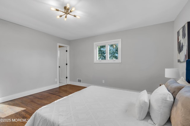 bedroom featuring a notable chandelier and wood-type flooring