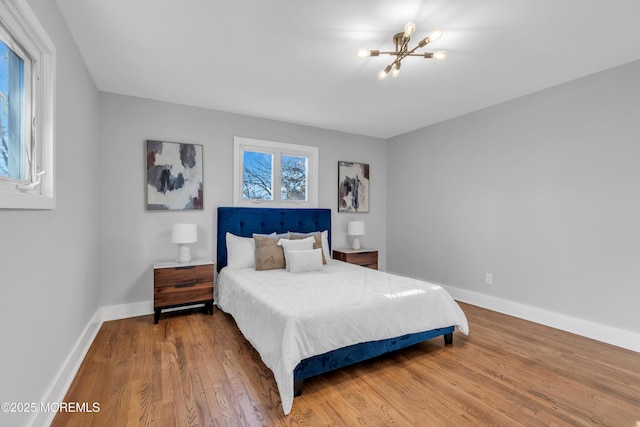 bedroom with a chandelier and wood-type flooring