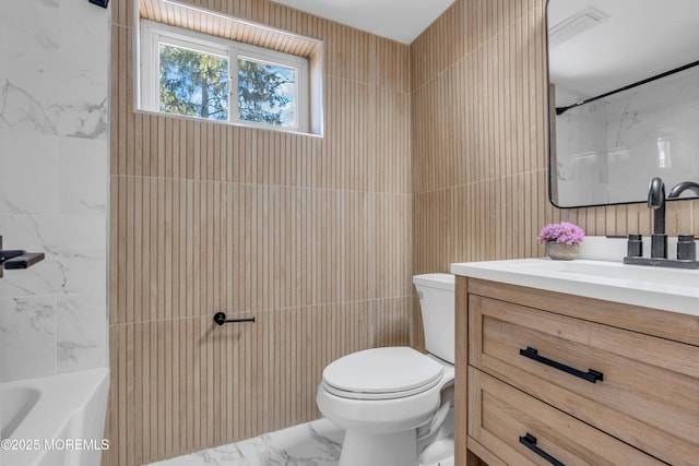 full bathroom with toilet, bathtub / shower combination, tile walls, and vanity