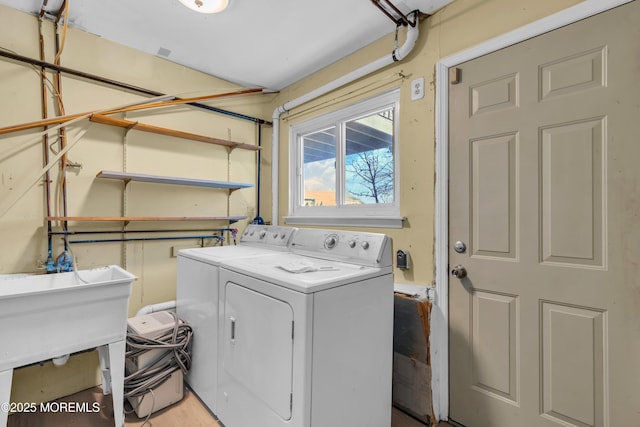 clothes washing area featuring sink and washing machine and clothes dryer